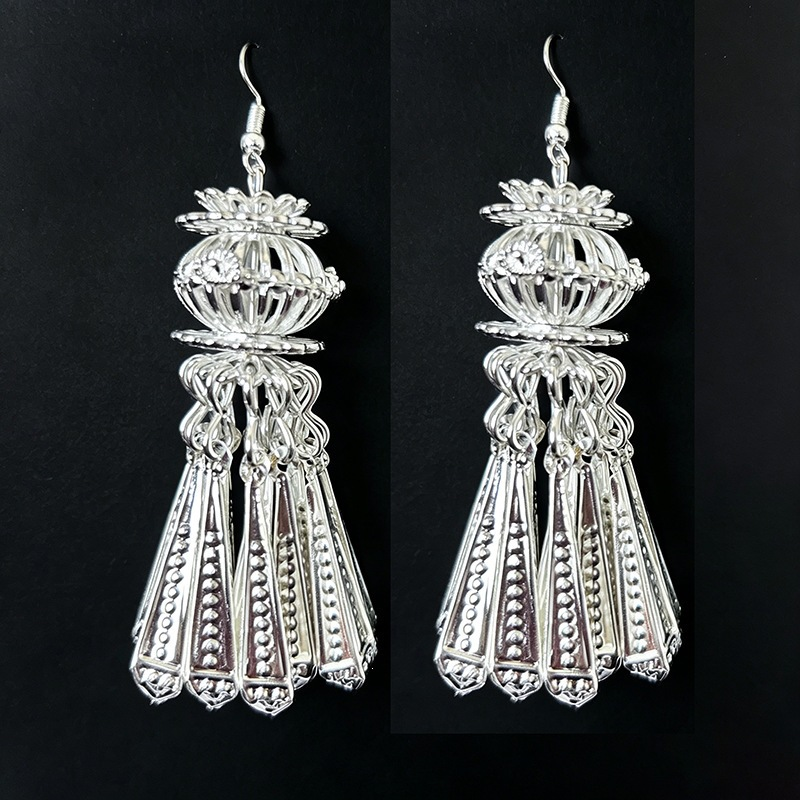 Ornate silver drop earrings with lantern-inspired filigree and tassel details